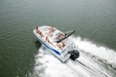 Aerial view of the Starcraft SVX 171 OB at speed with passengers seated on the open deck and an outboard on the transom