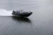 Starcraft STX 2050 planing across dark open water, throwing a bow wave behind it