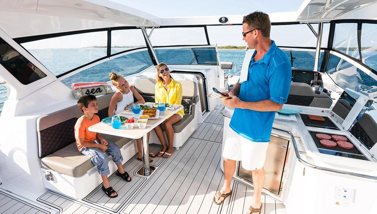 Guests at the table in the Aquila 36 Sport cockpit beside the helm