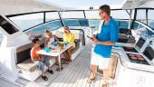 Guests at the table in the Aquila 36 Sport cockpit beside the helm