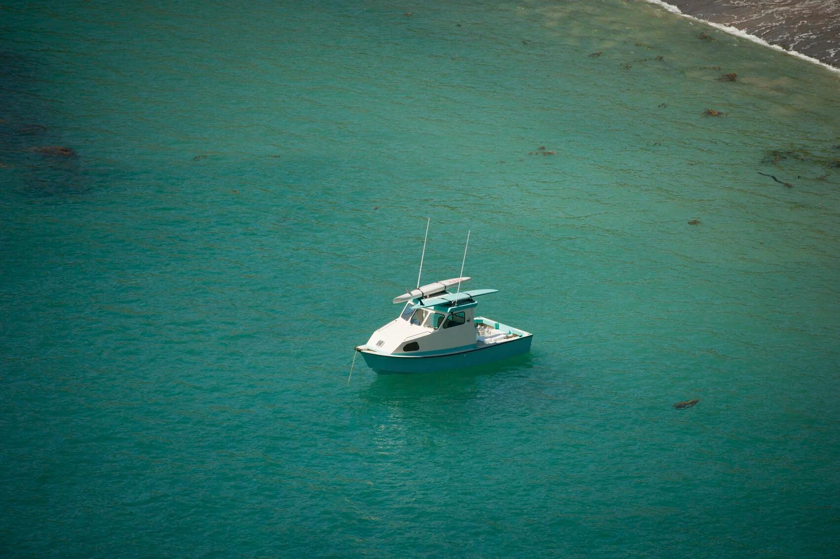 Aerial view of a Greenough 21 pilothouse at anchor in clear green water