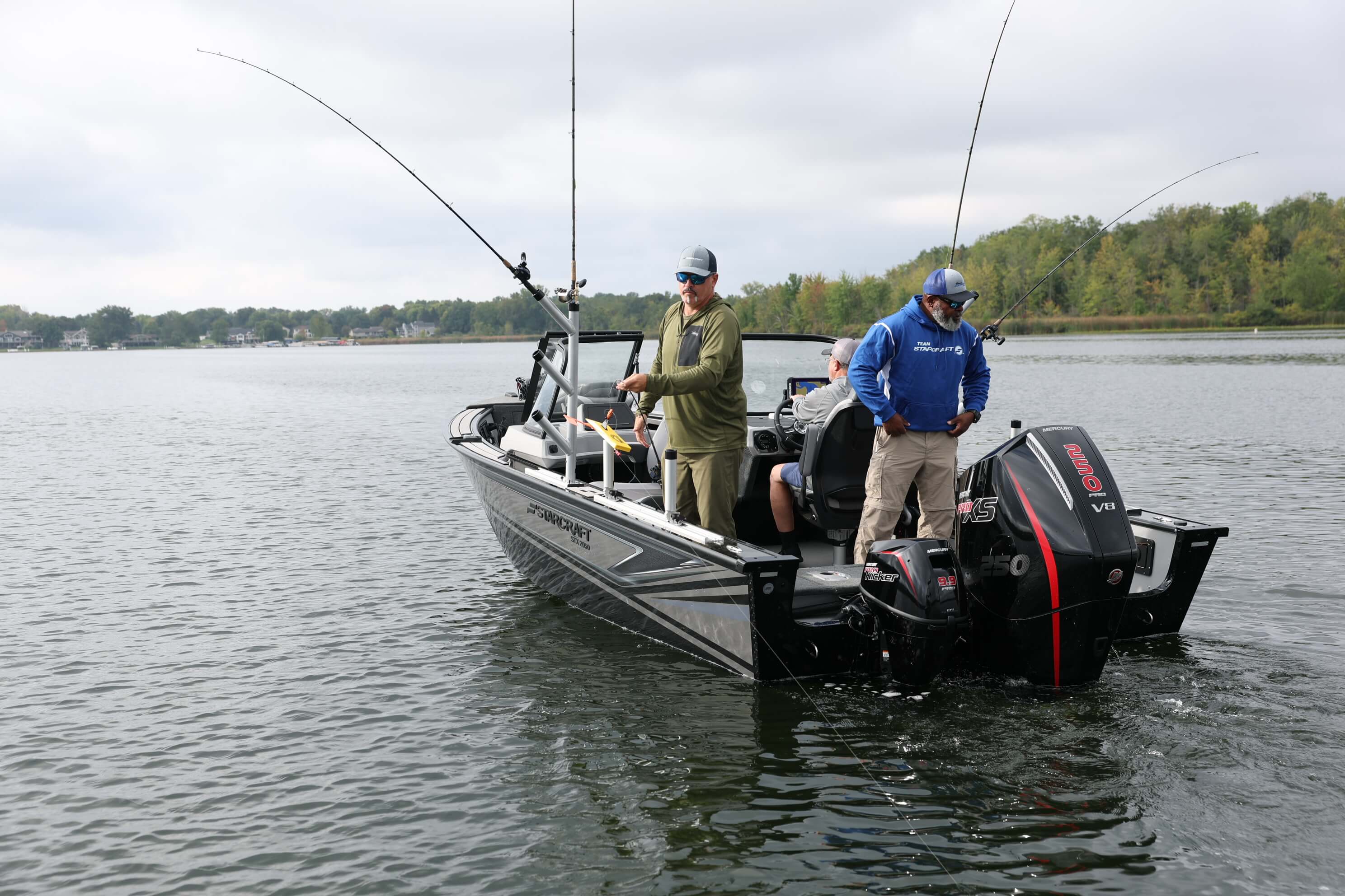 Stern view of a Starcraft STX 2050 with two anglers and fishing rods up, outboard motor on the transom