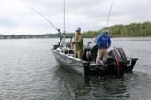 Stern view of a Starcraft STX 2050 with two anglers and fishing rods up, outboard motor on the transom