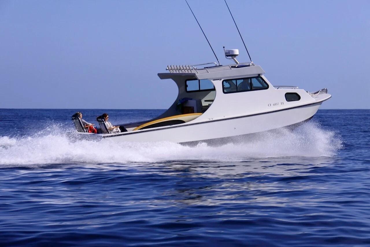White Anderson 31 sport boat with hardtop cruising at speed on deep blue water