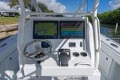 Yellowfin 32 Offshore helm with twin multifunction displays and a stainless-steel steering wheel