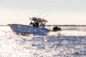 Yellowfin 32 Offshore running in bright sunlight with spray off the hull