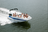 Starcraft SVX 171 OB running across calm water with a group of passengers on board, white hull with blue graphics and black bimini