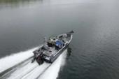 Aerial view from behind of a Starcraft STX 2050 under power, showing the open deck and outboard motor