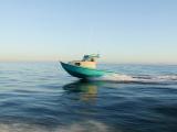 Teal Greenough 17 pilothouse skiff underway on open sea at dusk, side profile
