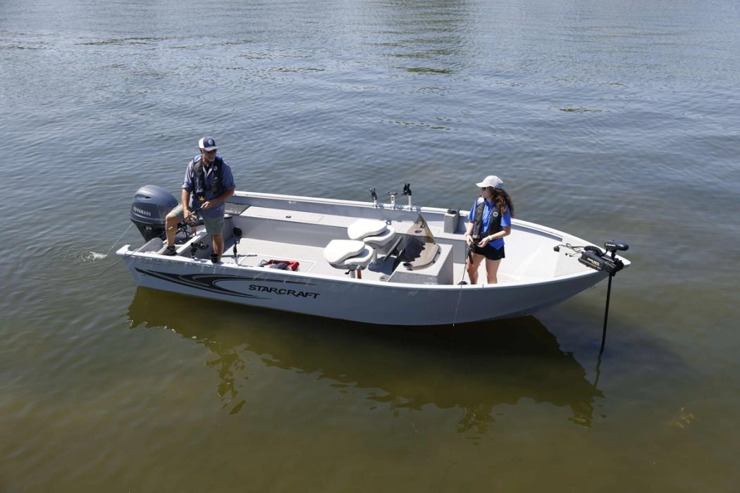 Starcraft Freedom 180 SC aluminium side console utility boat with two anglers aboard, bow-quarter view on the water