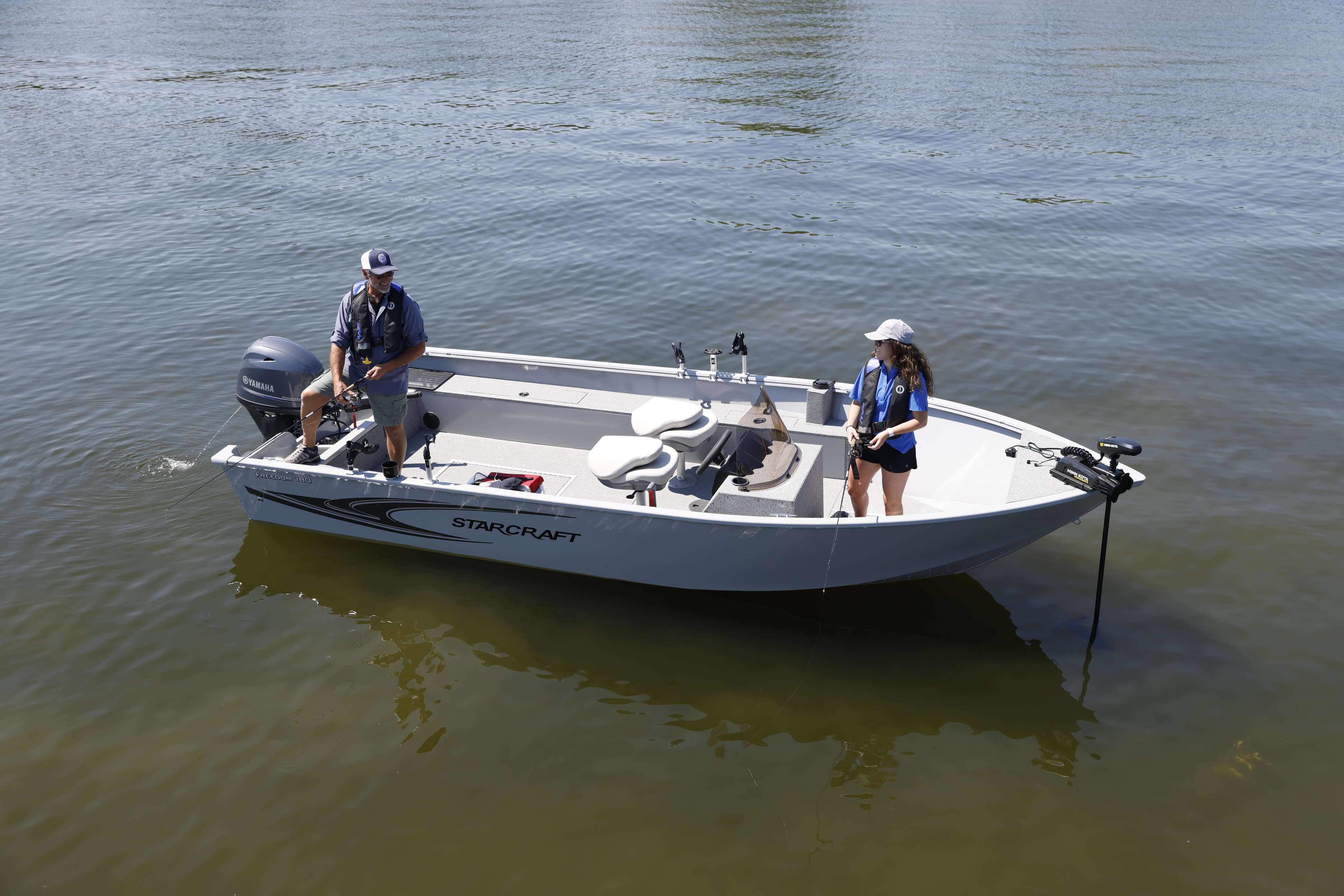 Starcraft Freedom 180 SC aluminium side console utility boat with two anglers aboard, bow-quarter view on the water