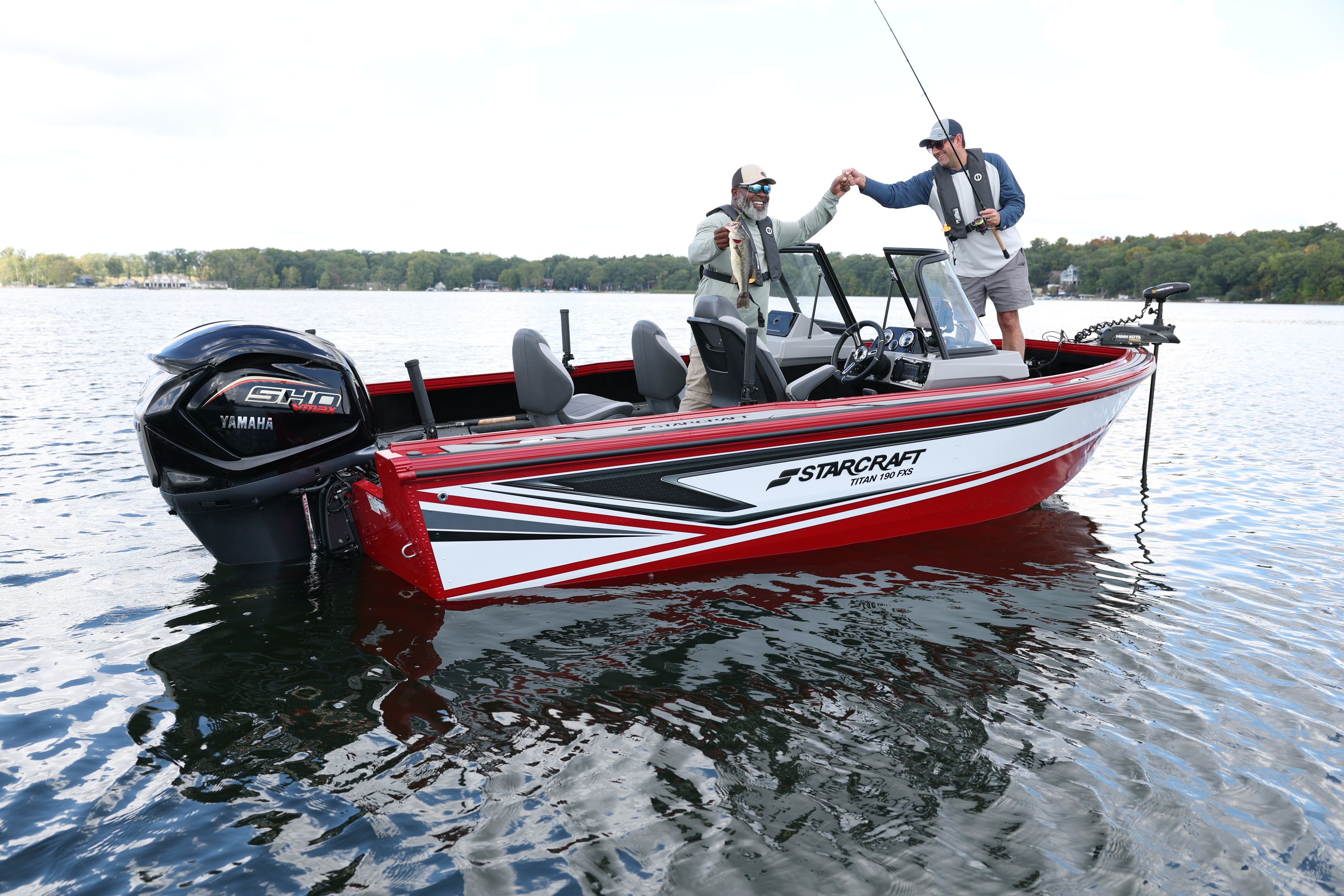Angler casting from the bow of a red and white Starcraft Storm fishing boat with an outboard motor on the transom