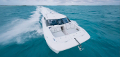 Aerial view of the Aquila 42 Coupe running fast, showing the bow lounge and hardtop