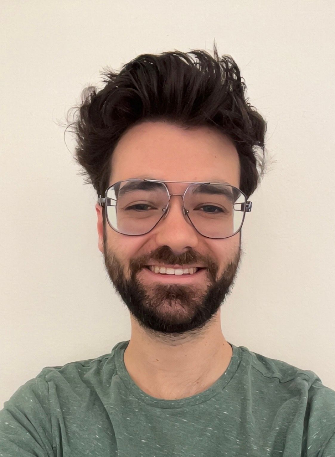 Smiling man with dark hair, beard and glasses