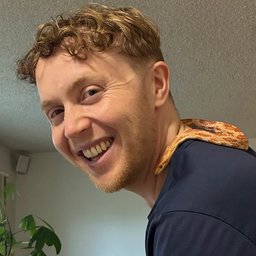 Smiling man with a snake draped over his shoulder