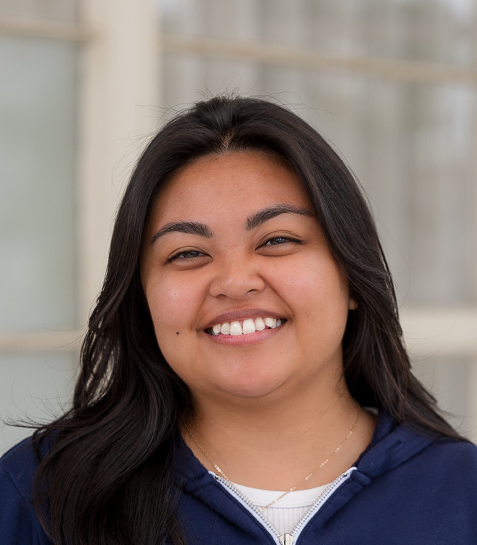 Woman smiling in an Astera zip-up hoodie