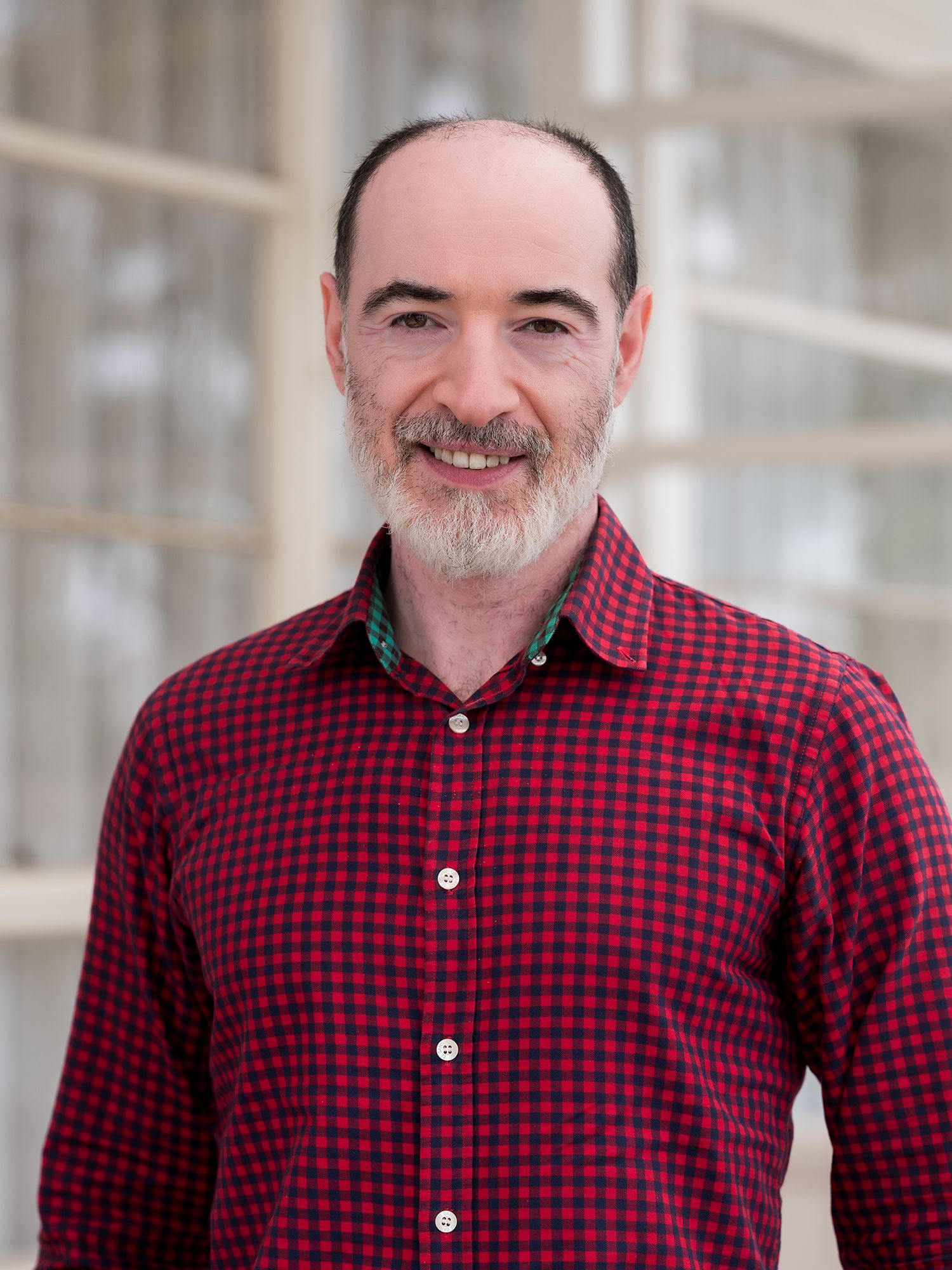 Smiling bearded man wearing a checkered shirt