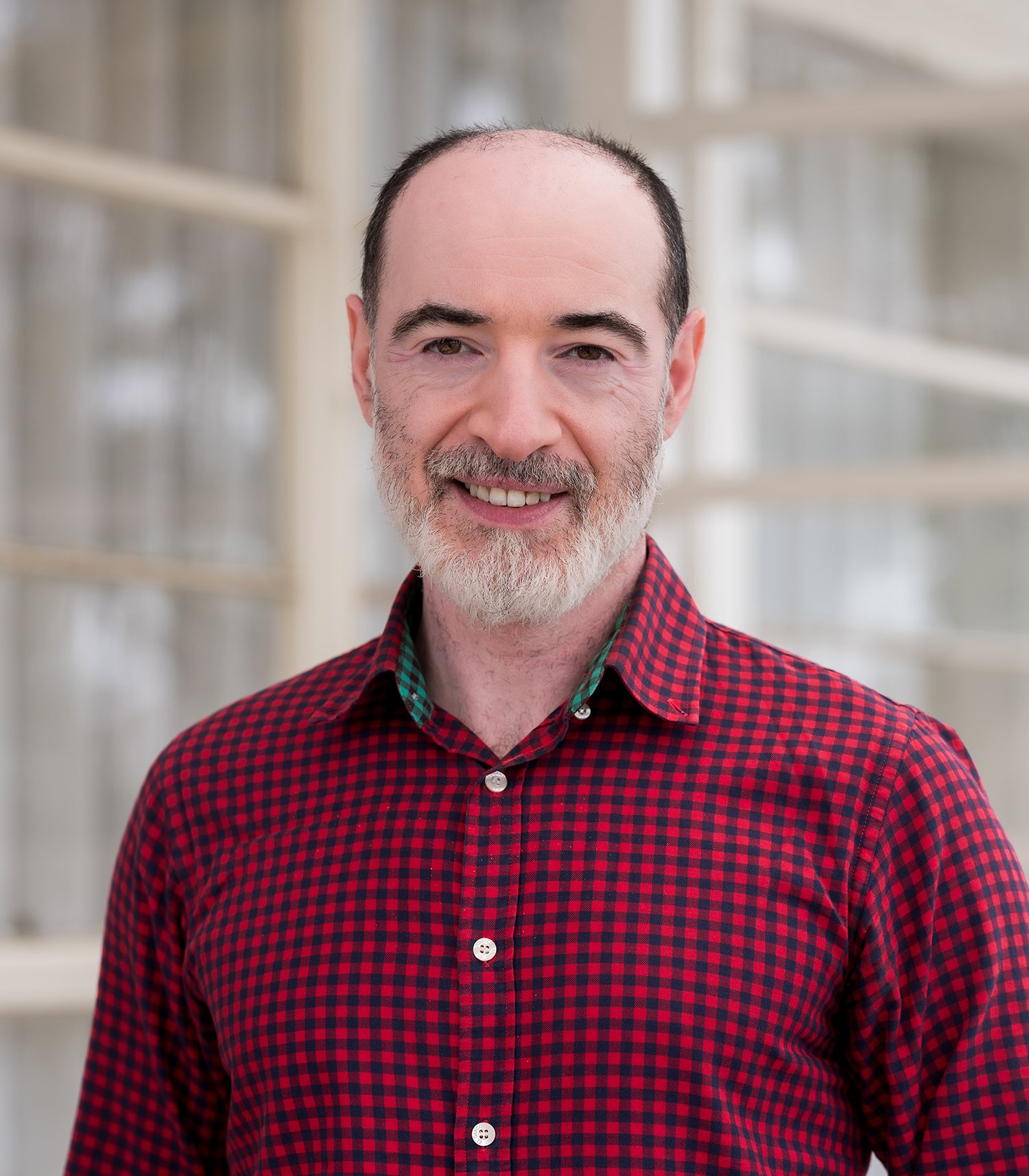 Smiling bearded man wearing a checkered shirt