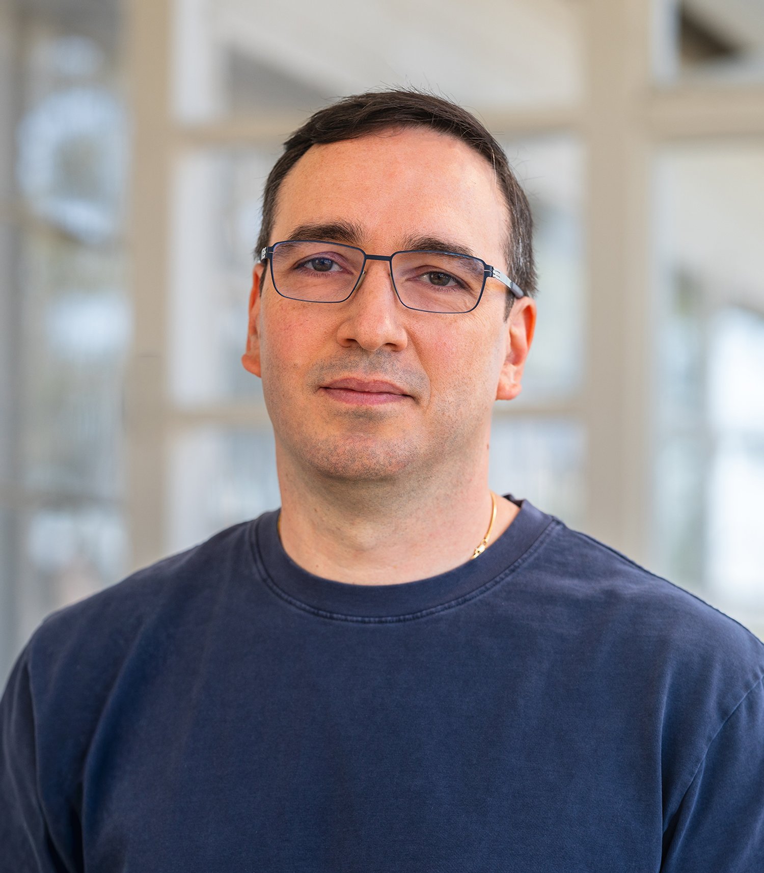 Man wearing glasses and a T-shirt faces the camera