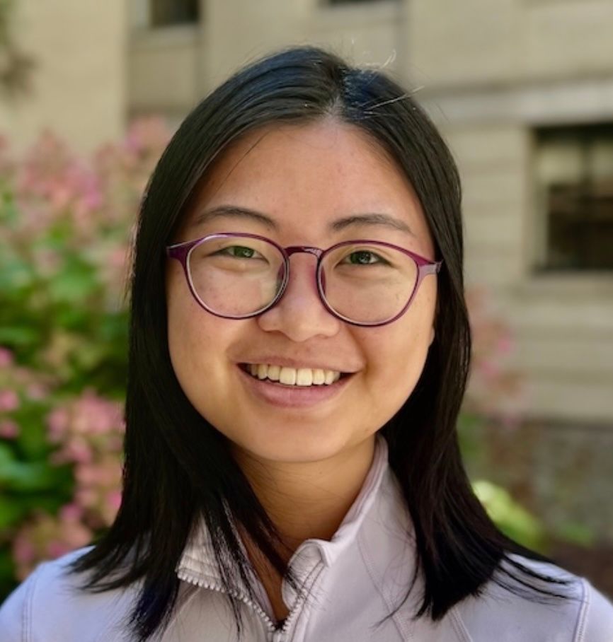 Woman with glasses smiling outdoors