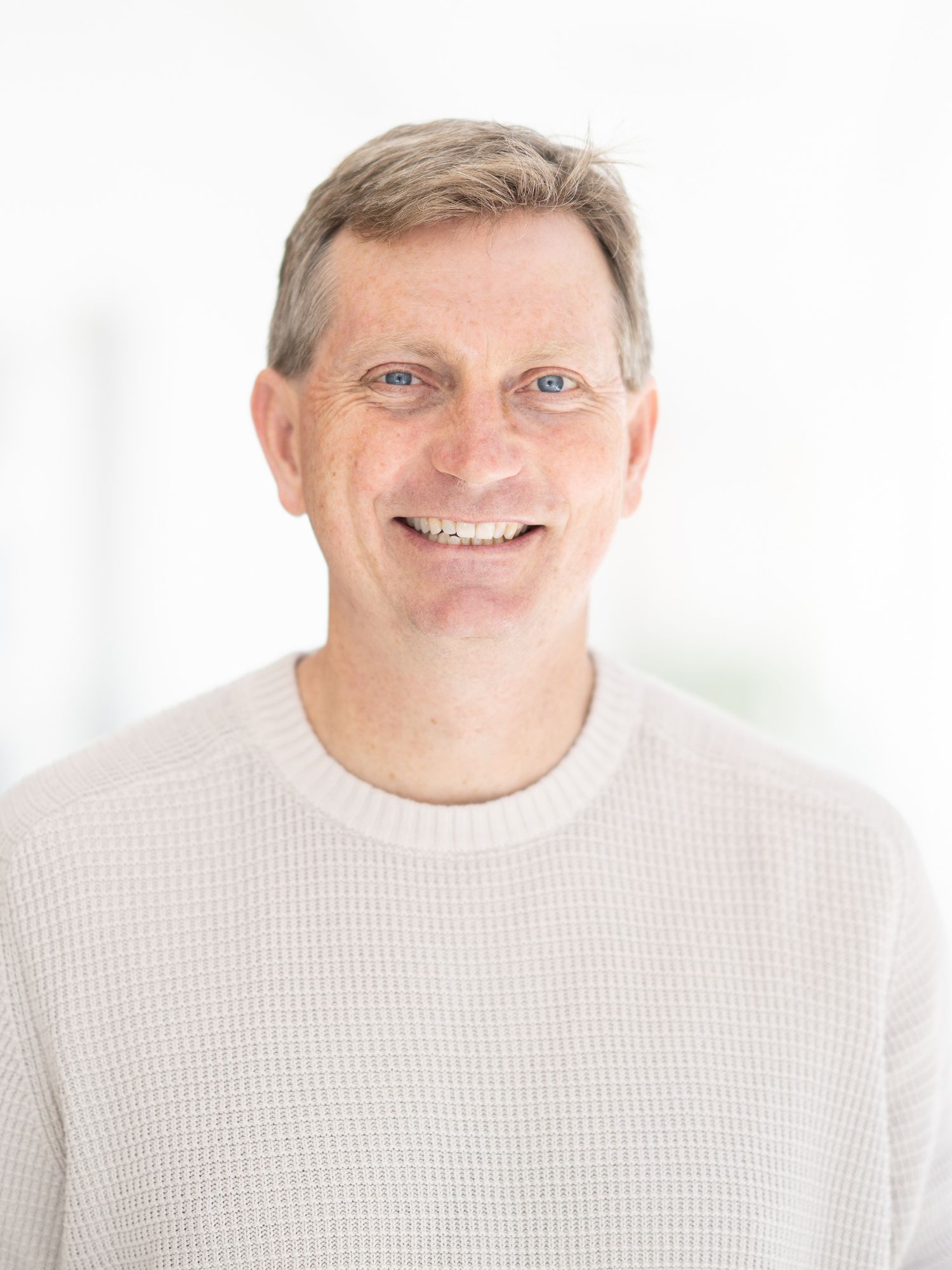 Smiling man wearing a light knit sweater