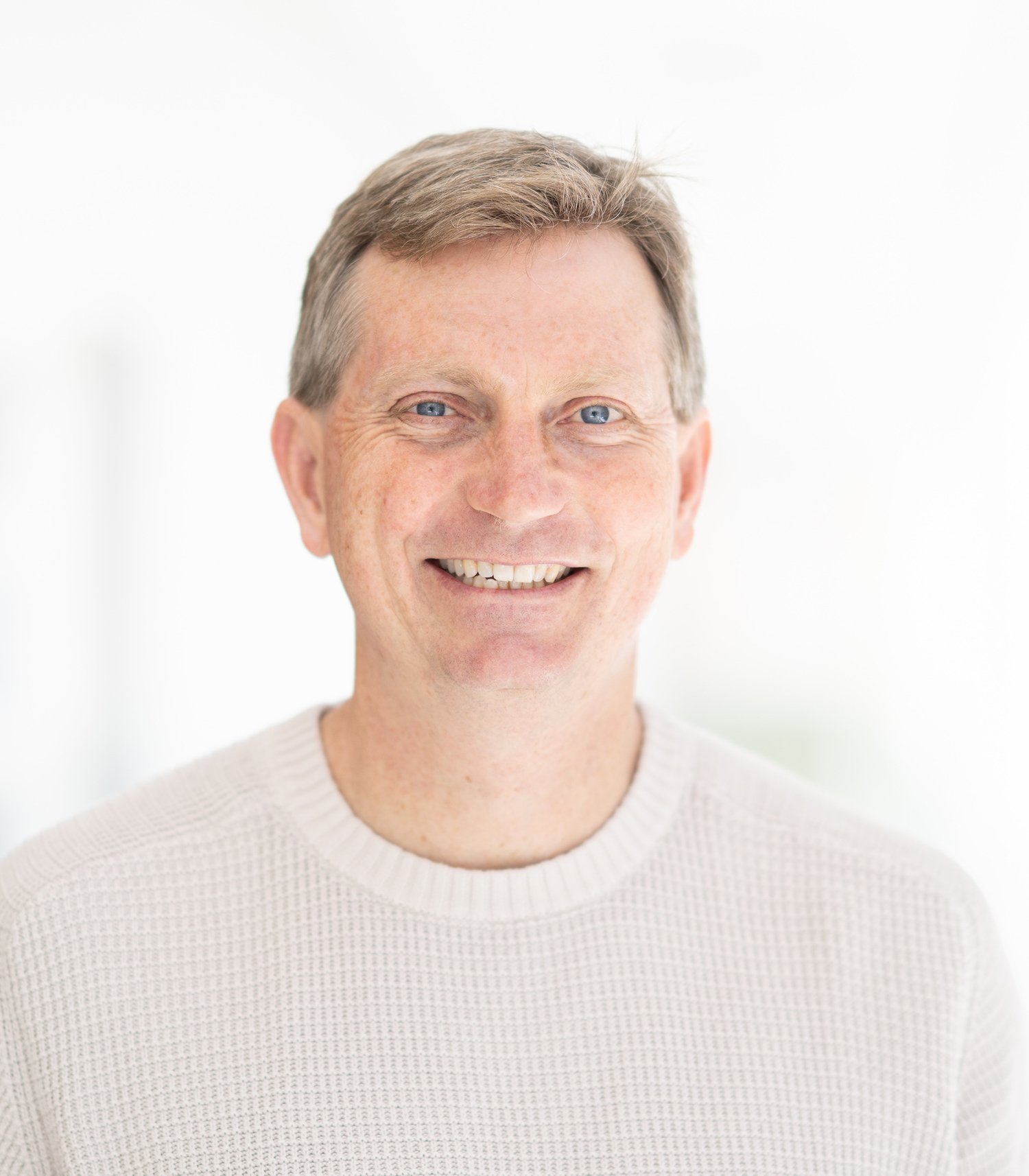 Smiling man wearing a light knit sweater
