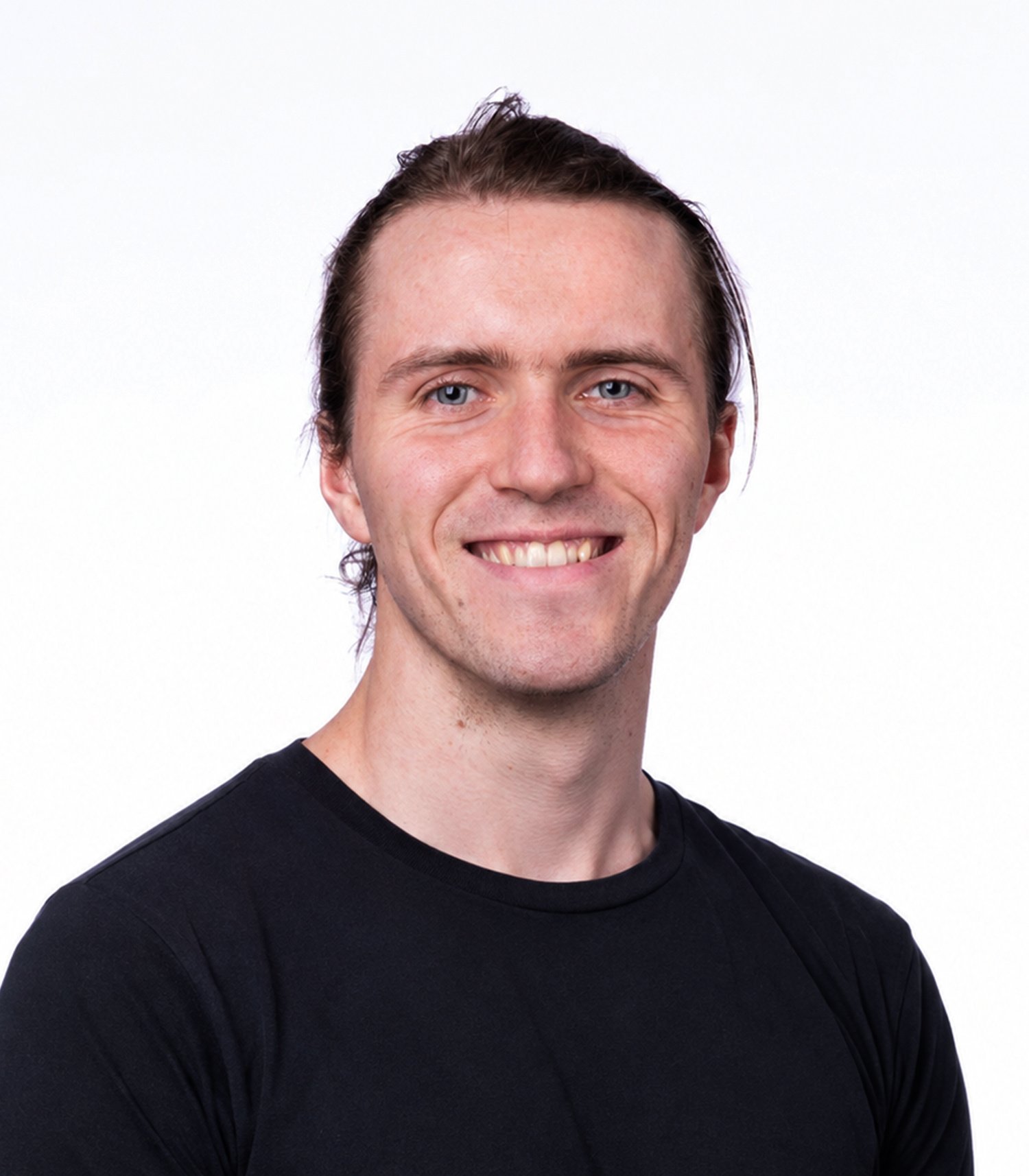 Smiling man with tied-back hair wearing a black T-shirt
