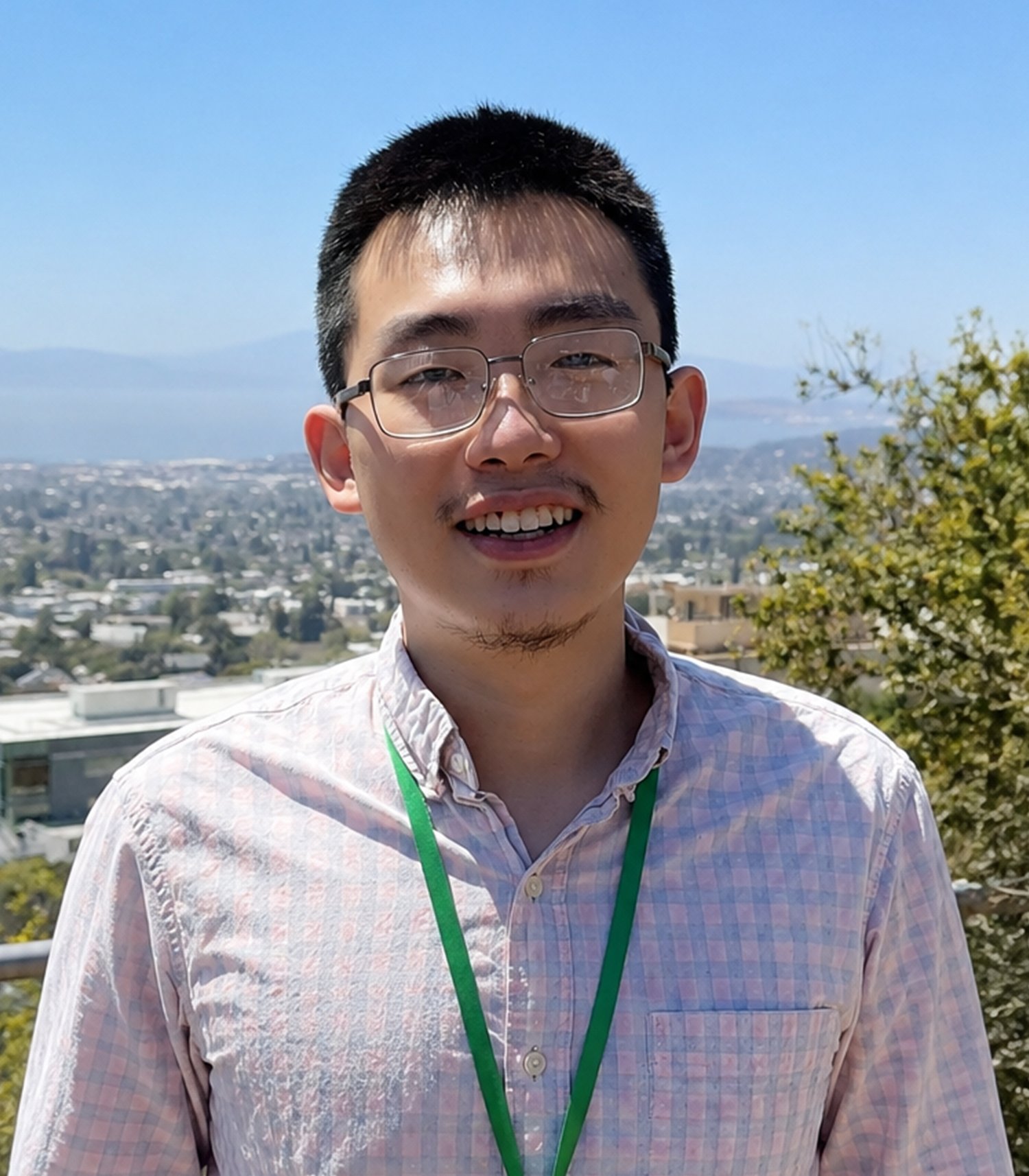 Smiling man wearing glasses and a lanyard outdoors