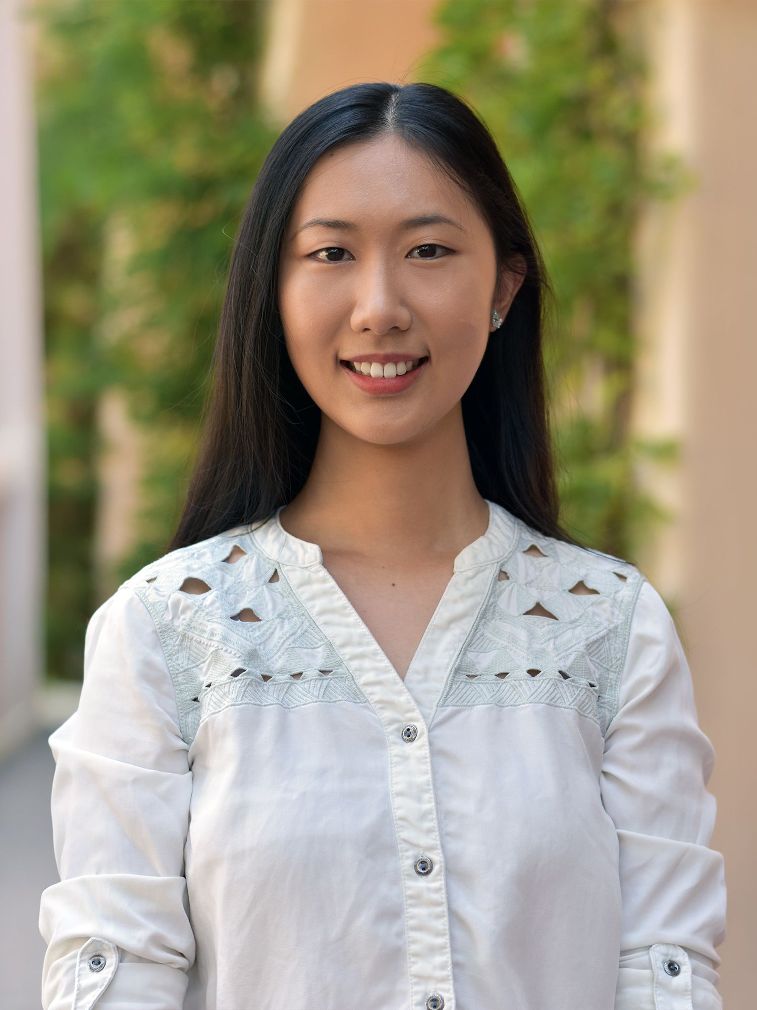 Woman with long dark hair smiling at the camera