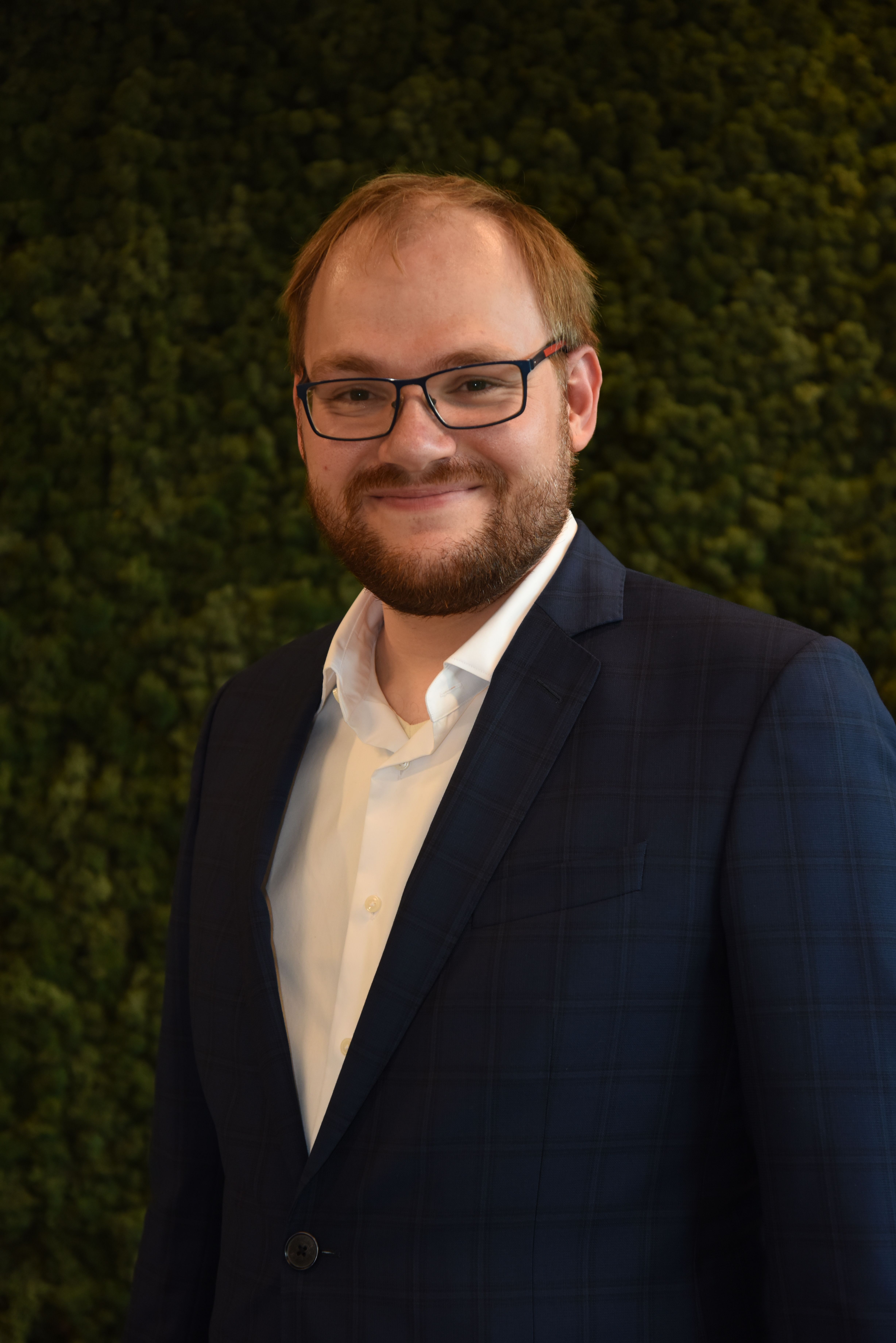 Man with glasses and beard wearing a suit jacket