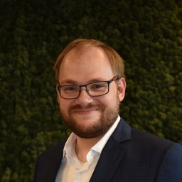 Man with glasses and beard wearing a suit jacket
