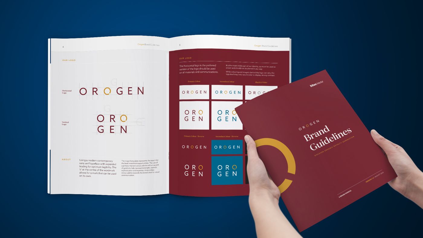 Hands holding the Orogen Royalties brand guidelines book, open to the logo pages