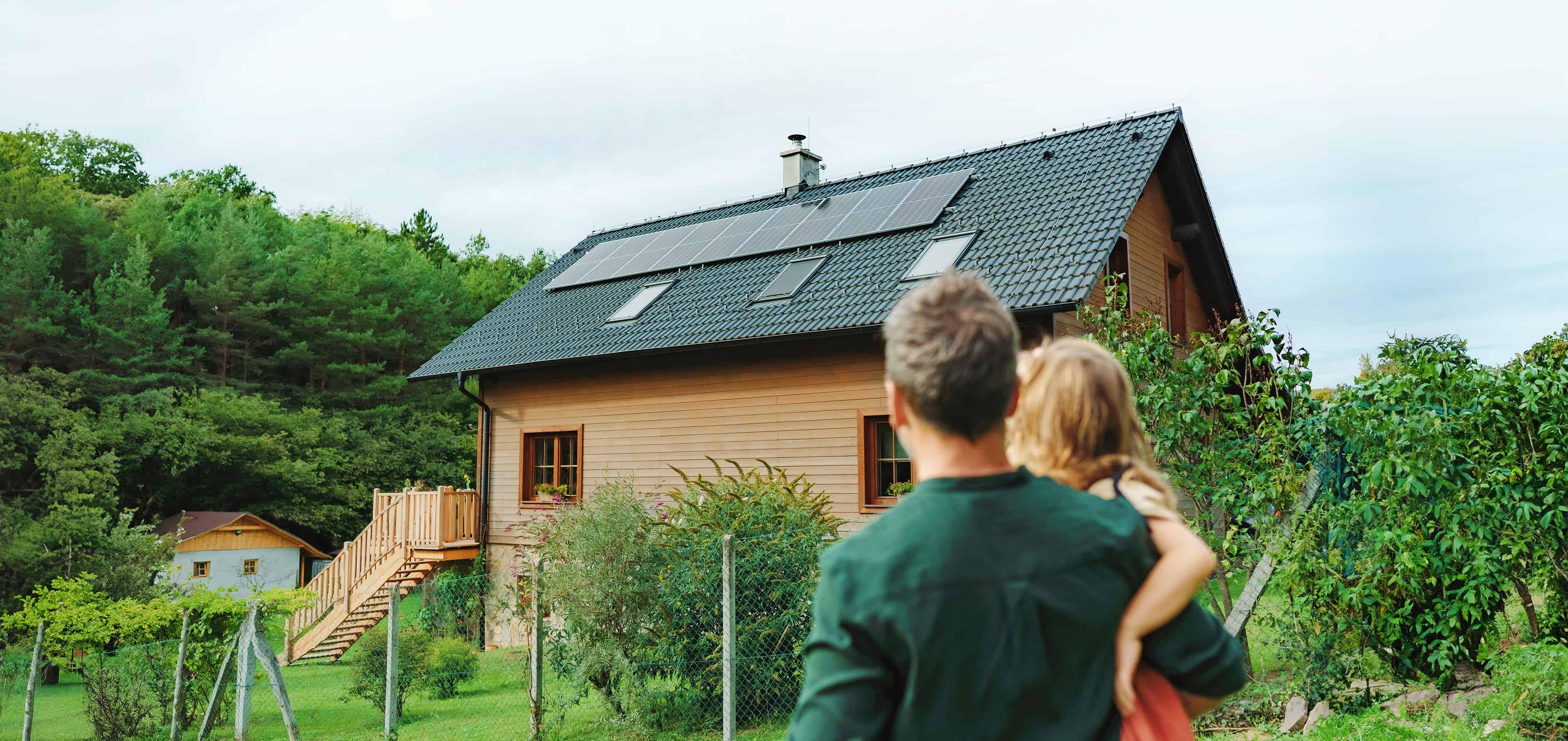 Mann mit Kind auf dem Arm, die auf Ihr Haus schauen