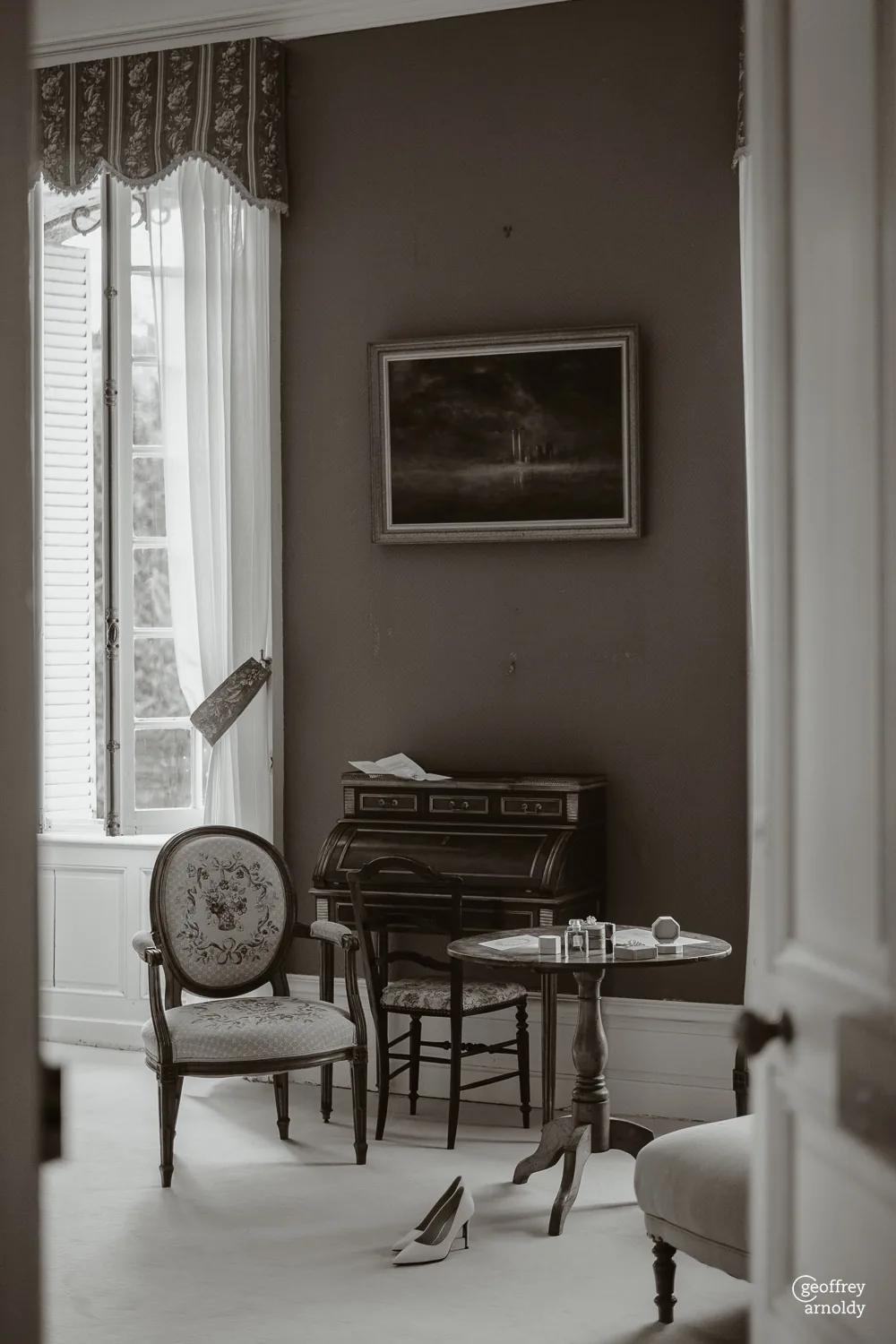 A château bedroom in black and white, its window and writing desk