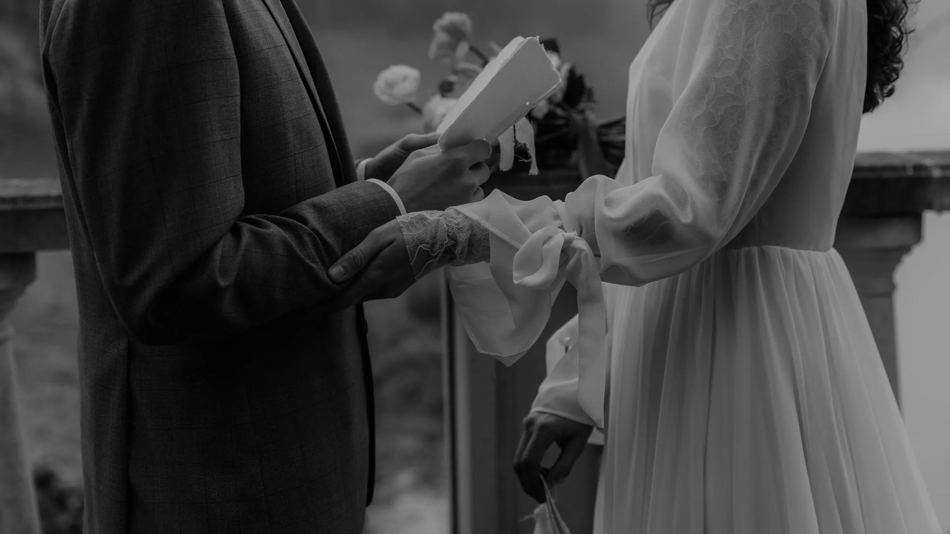 Les mains des mariés au moment de l'échange des vœux, en noir et blanc