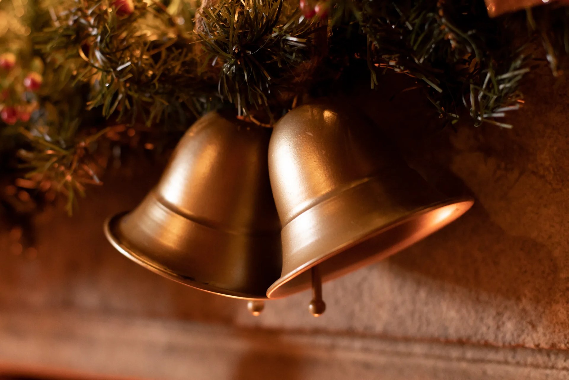 Deux cloches dorées suspendues aux branches du sapin