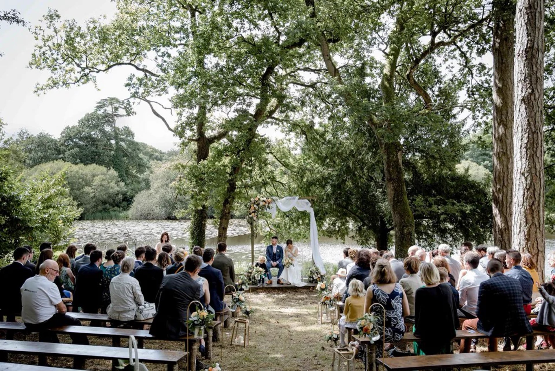 Cérémonie laïque sous les arbres, devant les invités assis