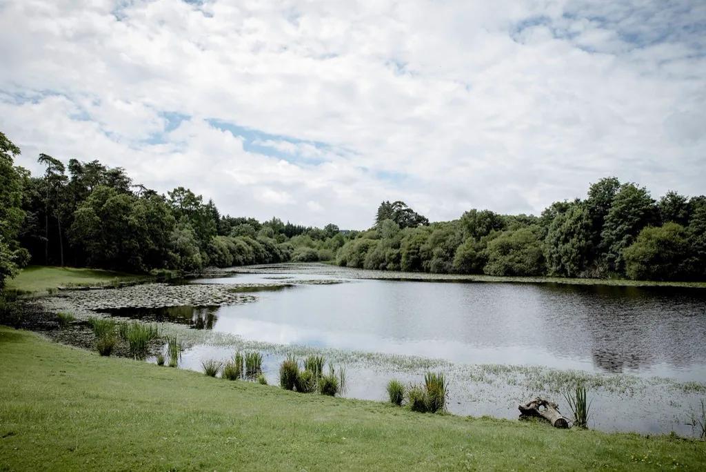 The lake and the estate's meadow under a broken sky