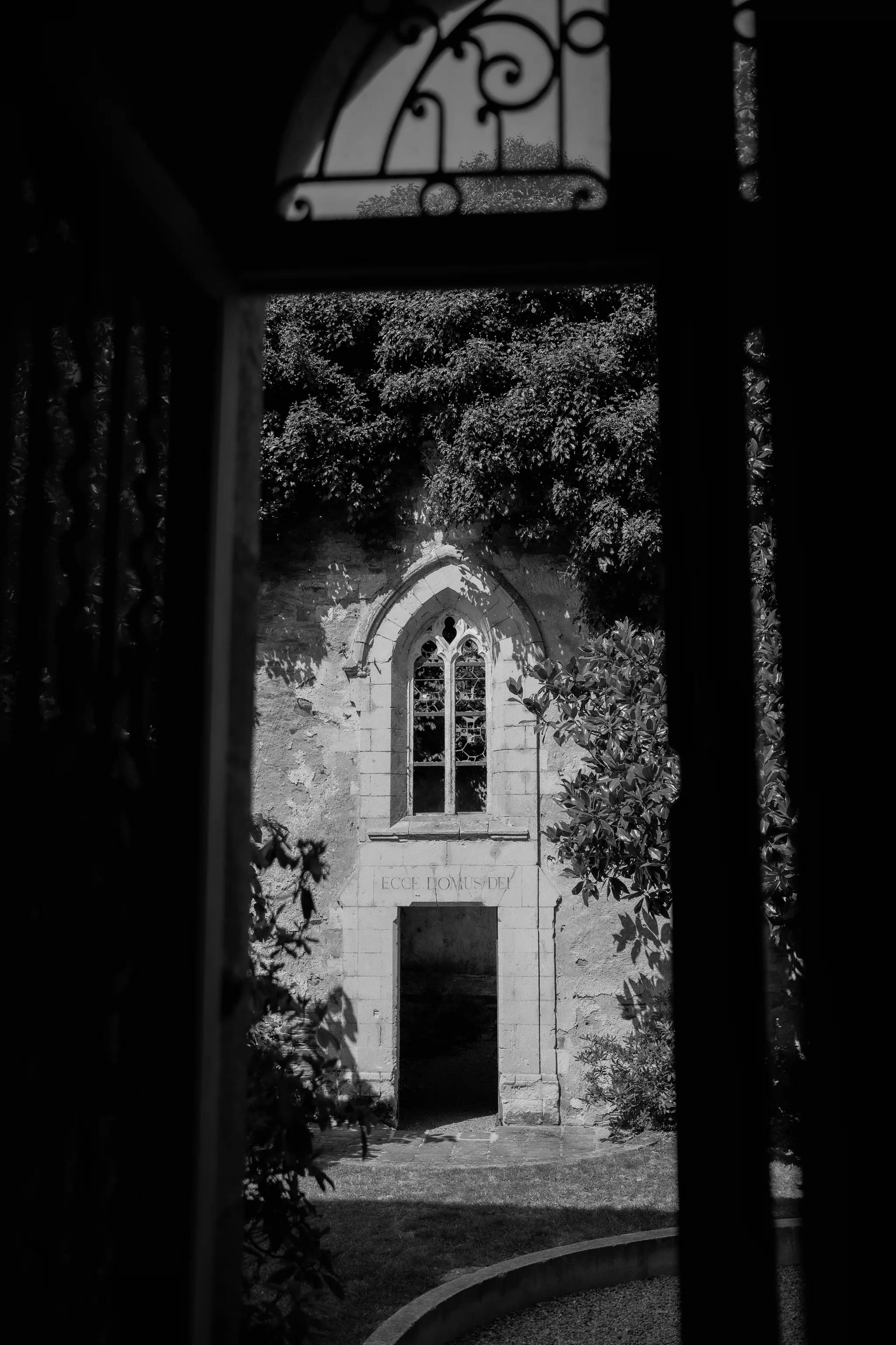 The estate's chapel seen through a vaulted porch, in black and white