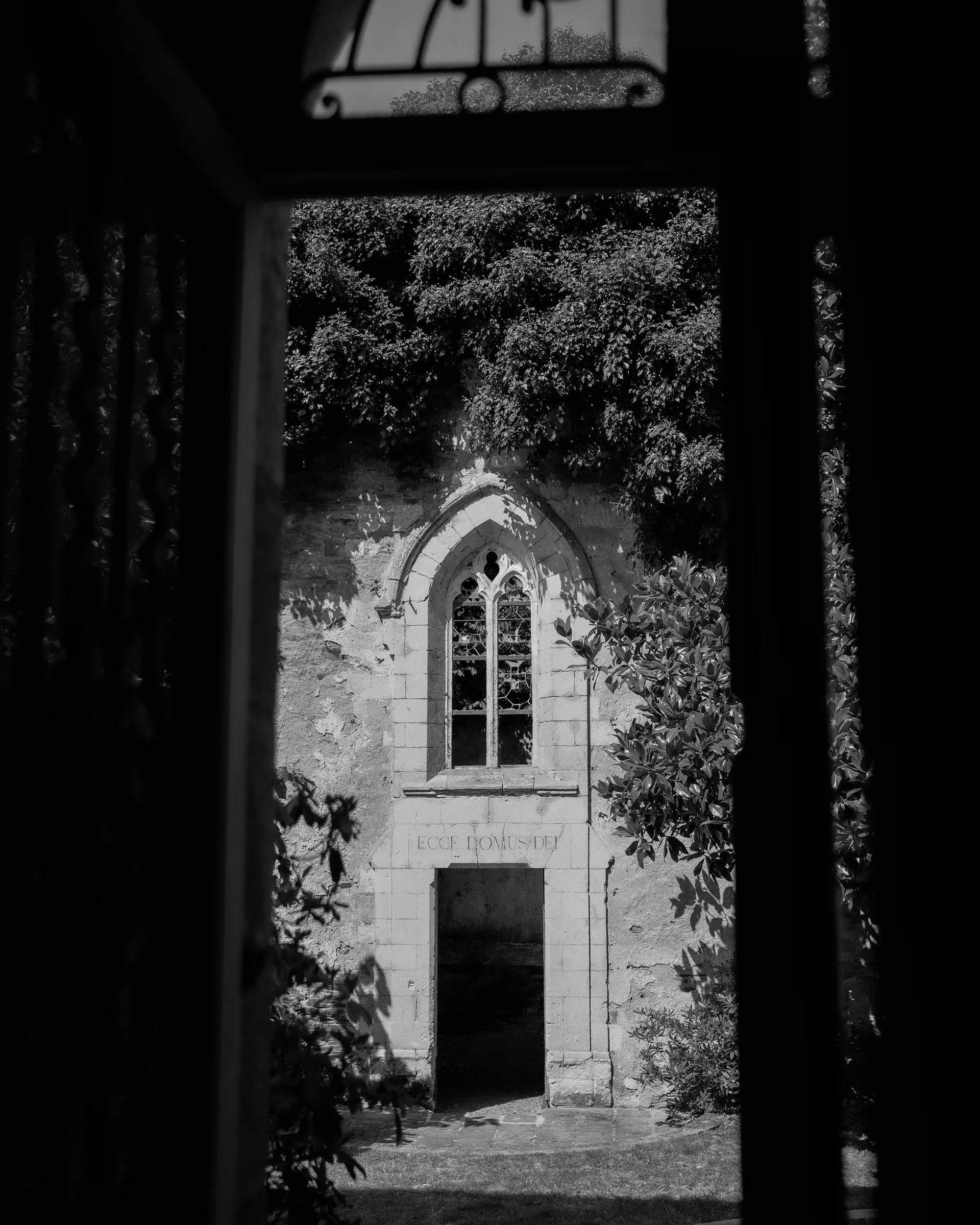 The estate's chapel seen through a vaulted porch, in black and white