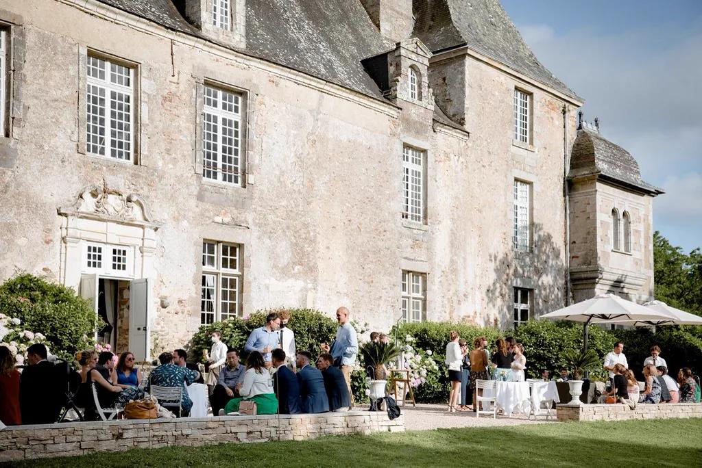 Cocktail des invités sur la pelouse, au pied de la façade