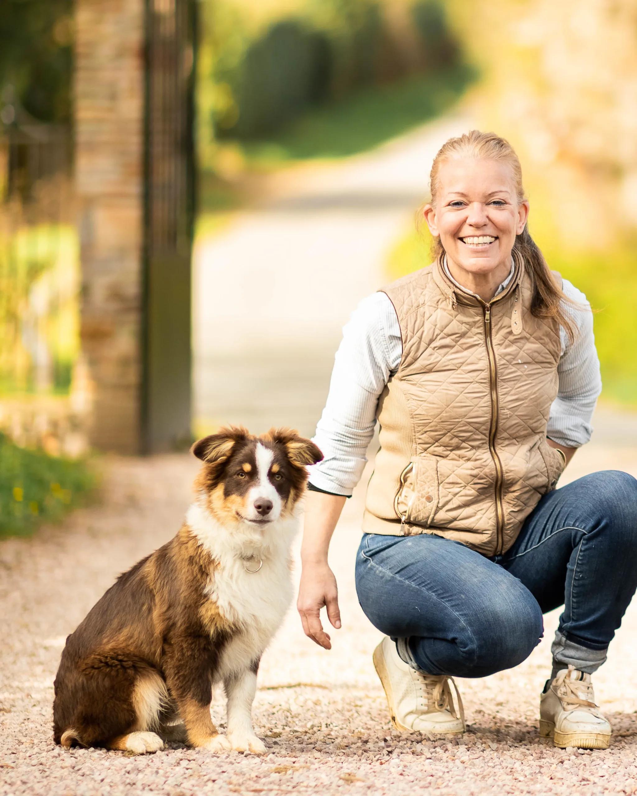 Olivia de Varreux, mistress of the house, with one of the estate's Australian shepherds, in the château driveway