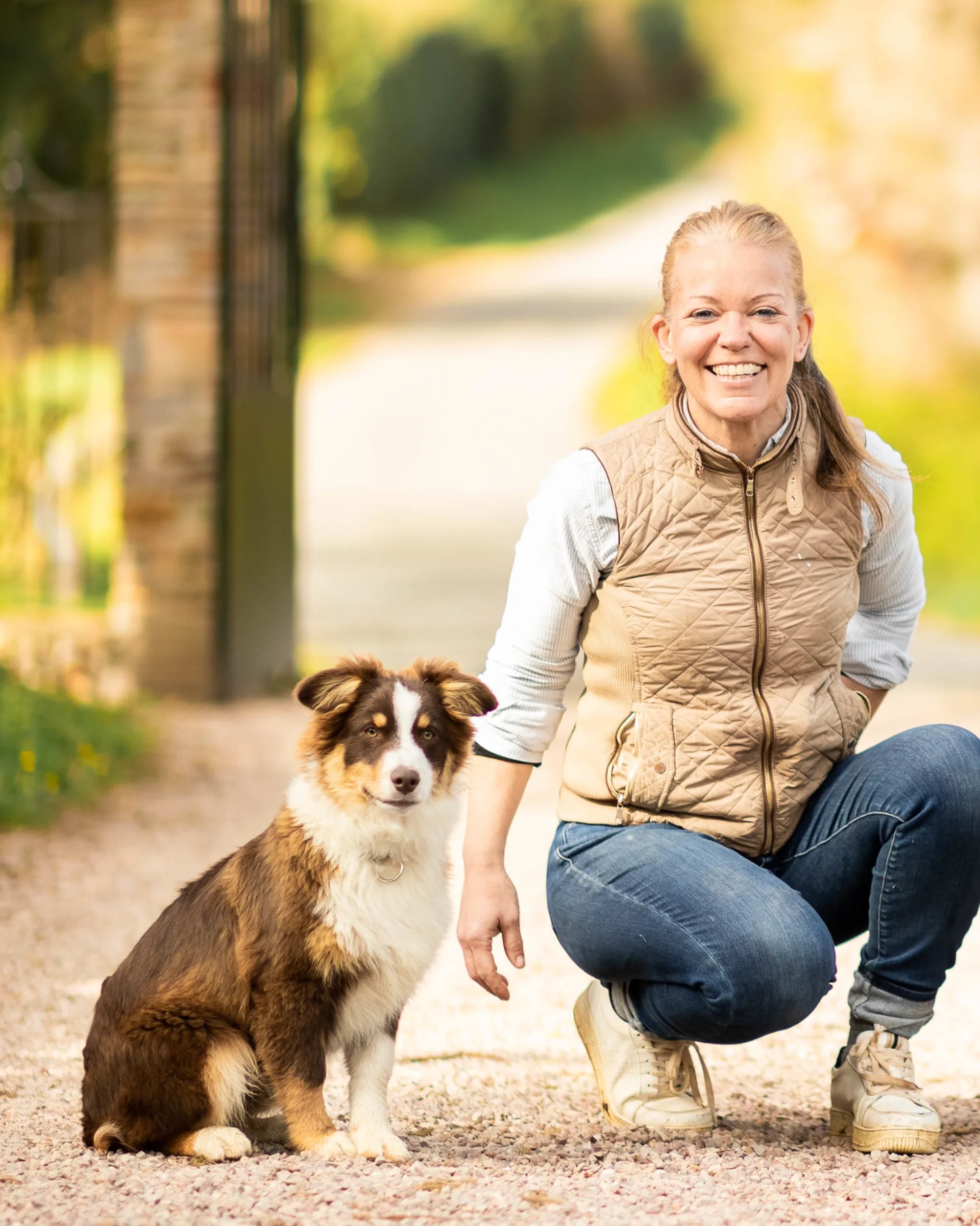 Olivia de Varreux, mistress of the house, with one of the estate's Australian shepherds, in the château driveway