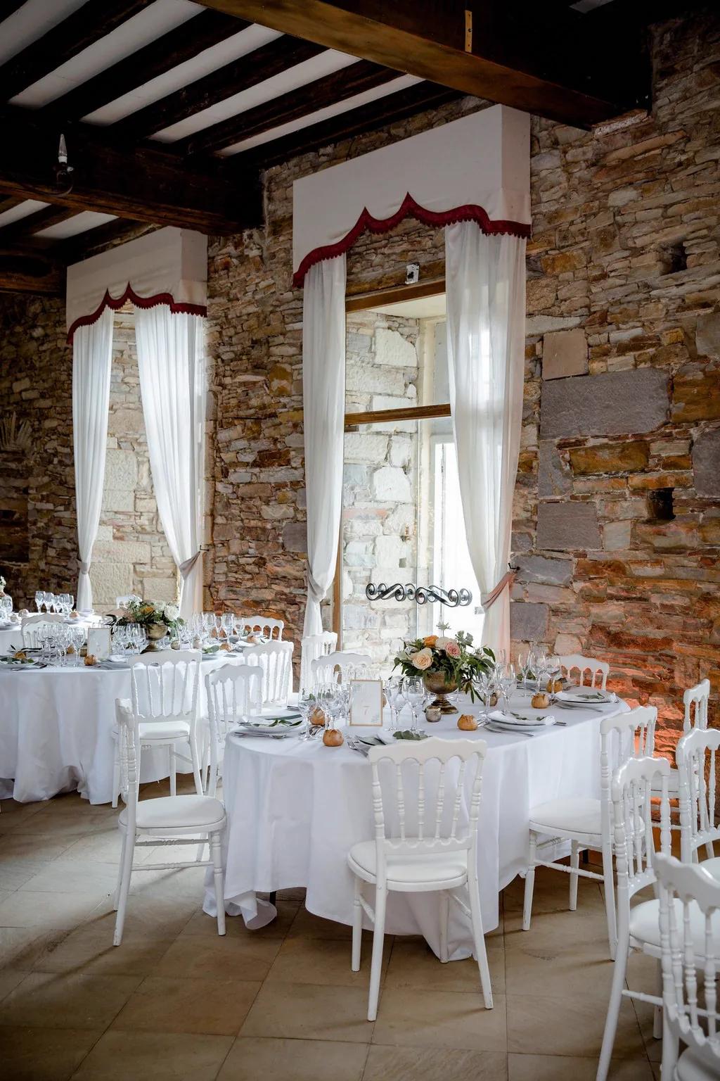 La salle de banquet dressée en blanc, sous ses poutres d'origine