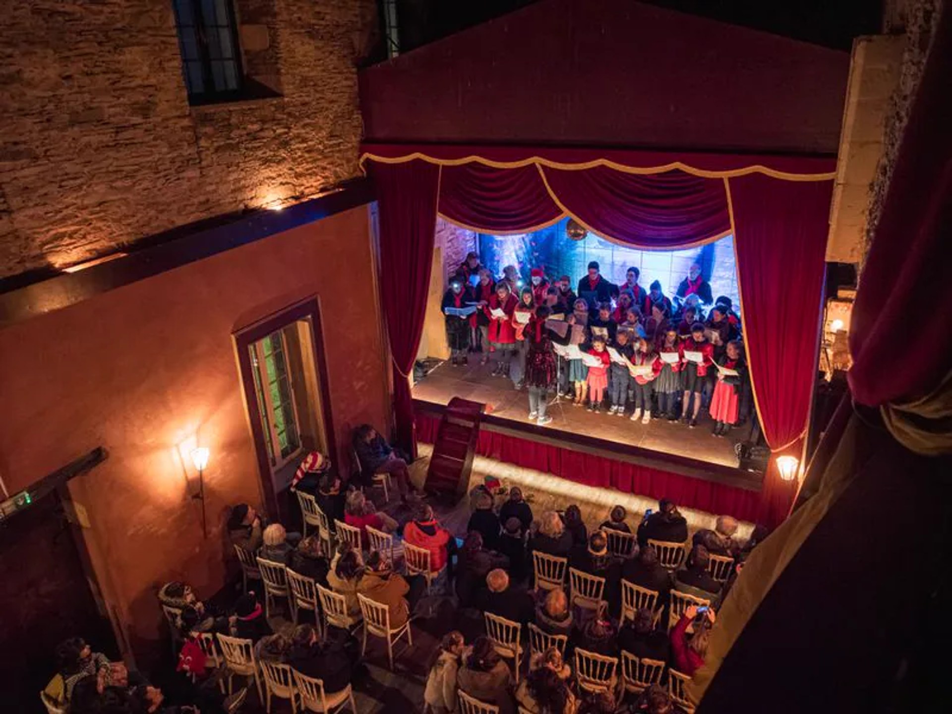La chorale sur la scène du théâtre, devant le public de Noël