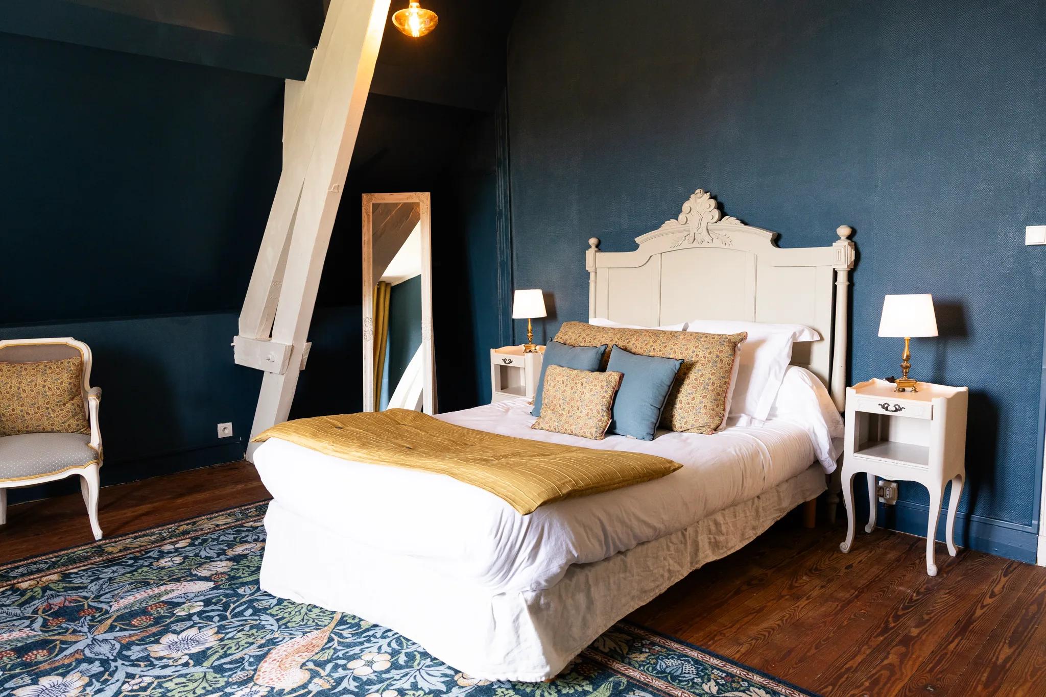 A château bedroom, its golden bedspread and fireplace