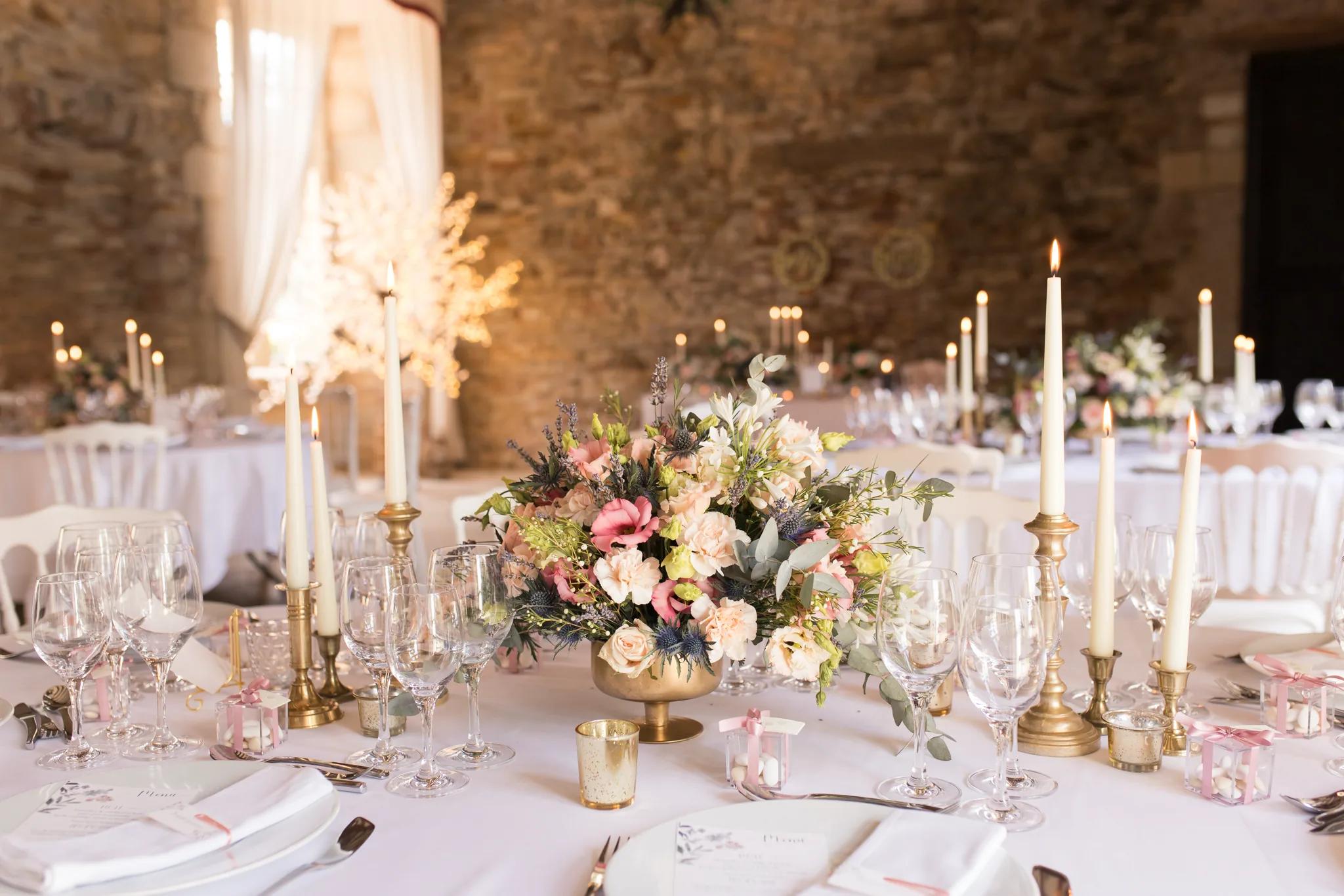 Table dressée au crépuscule, bouquet pastel et chandeliers dorés