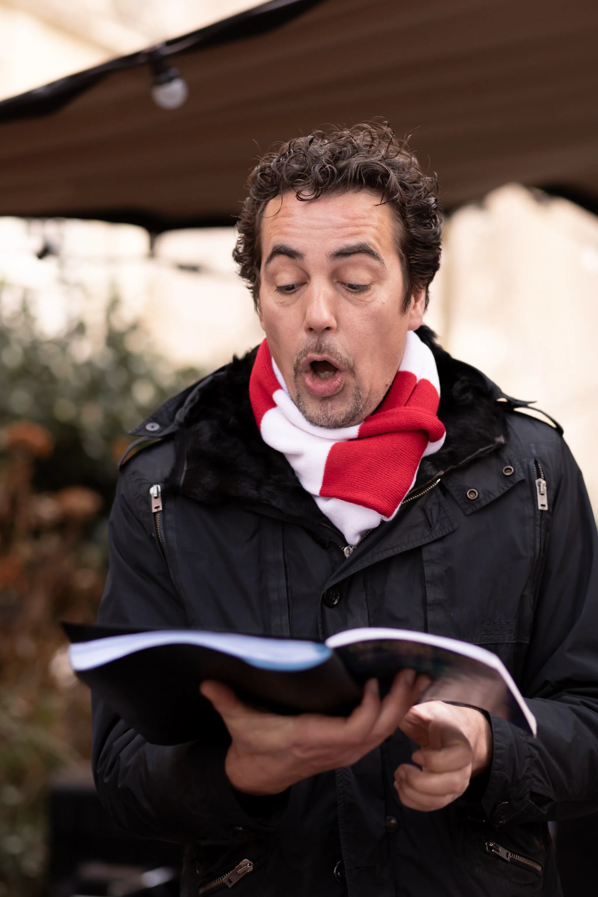 Un chanteur interprétant les airs de Noël, en extérieur