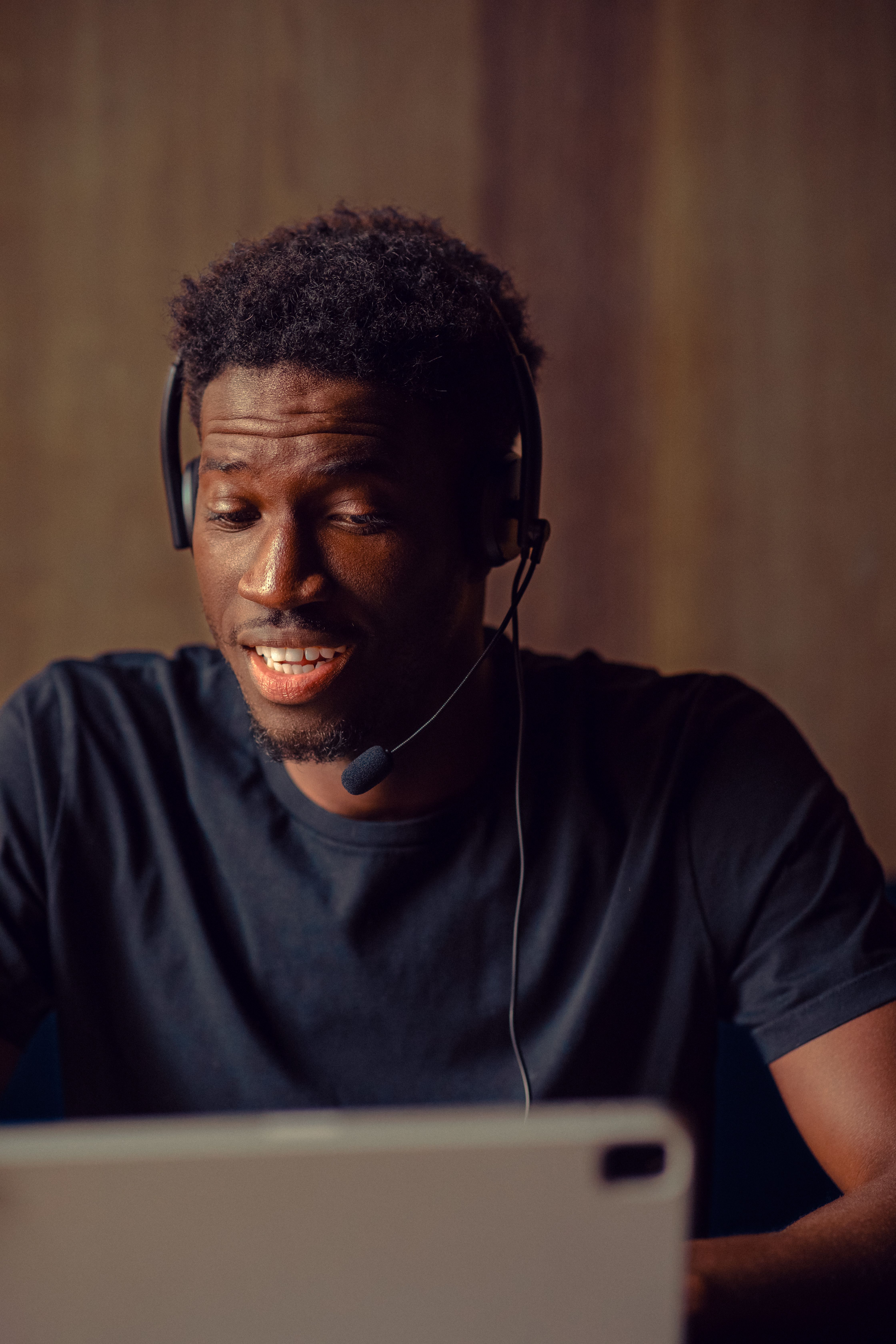 Man in a headset looking down at a tablet
