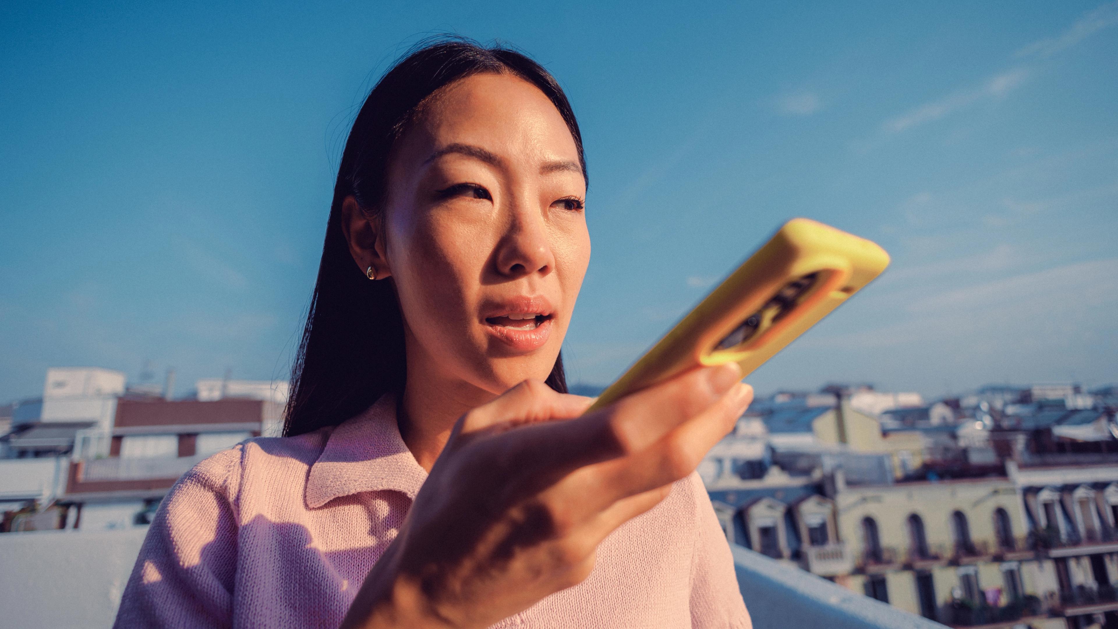 Woman speaking into her phone outside an office building at dusk
